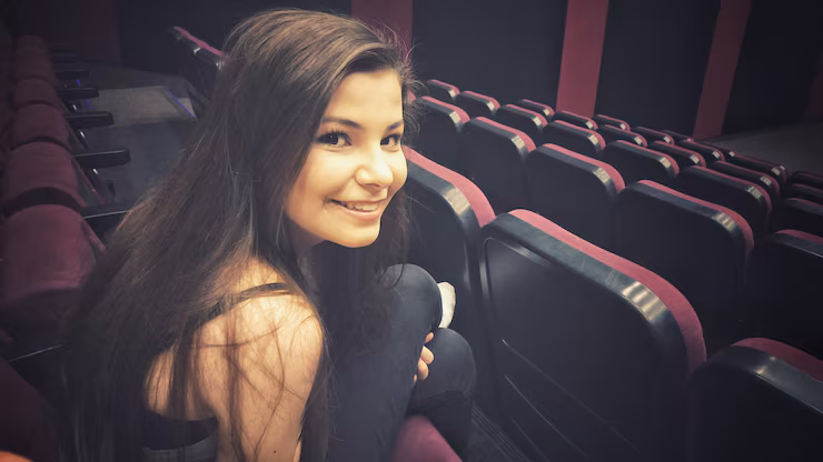 Portrait of young woman smiling at camera sitting in stadium chair